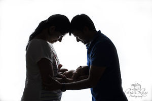 Silhouette of parents and their newborn baby
