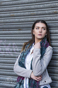 Portrait of woman leaning against shutters