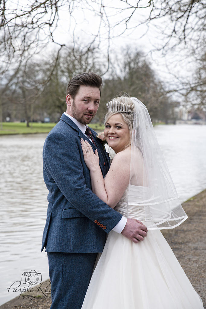 bride and groom standing at Bedford river bank