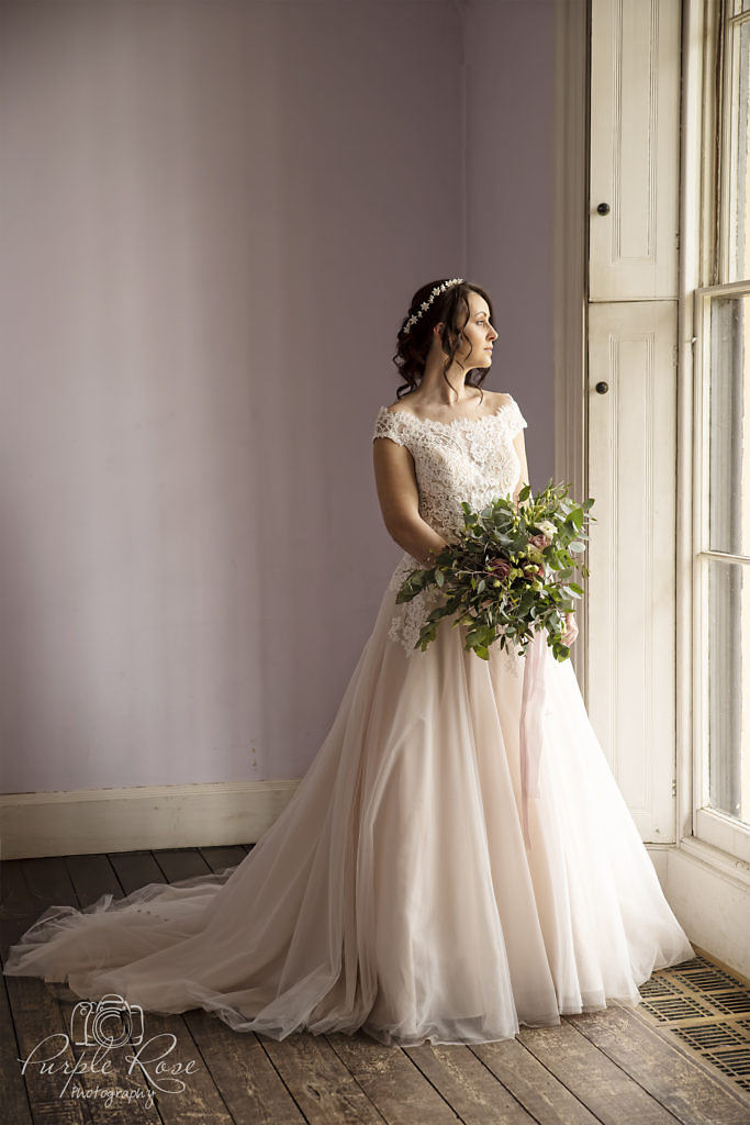 Bride standing by a tall window