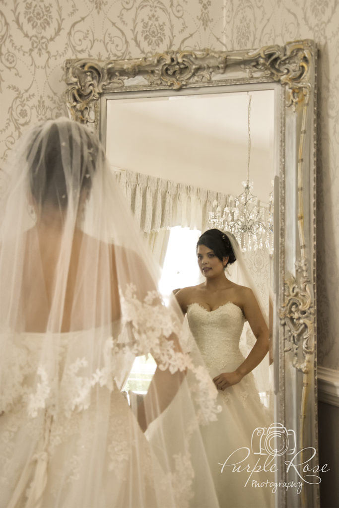 Bride checking her reflection in the mirror.