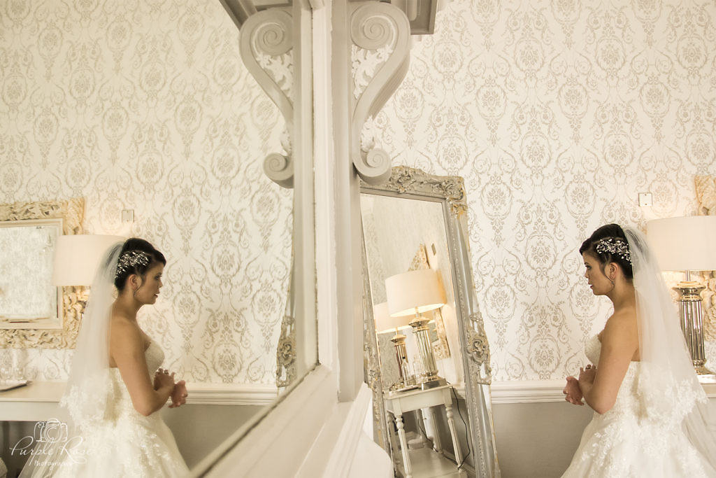 Reflection of a bride checking her reflection in the mirror