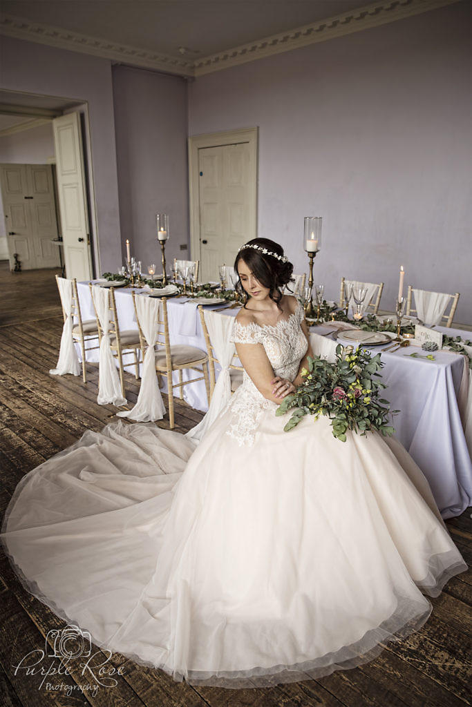 bride sat on chair with wedding dress swirling round her