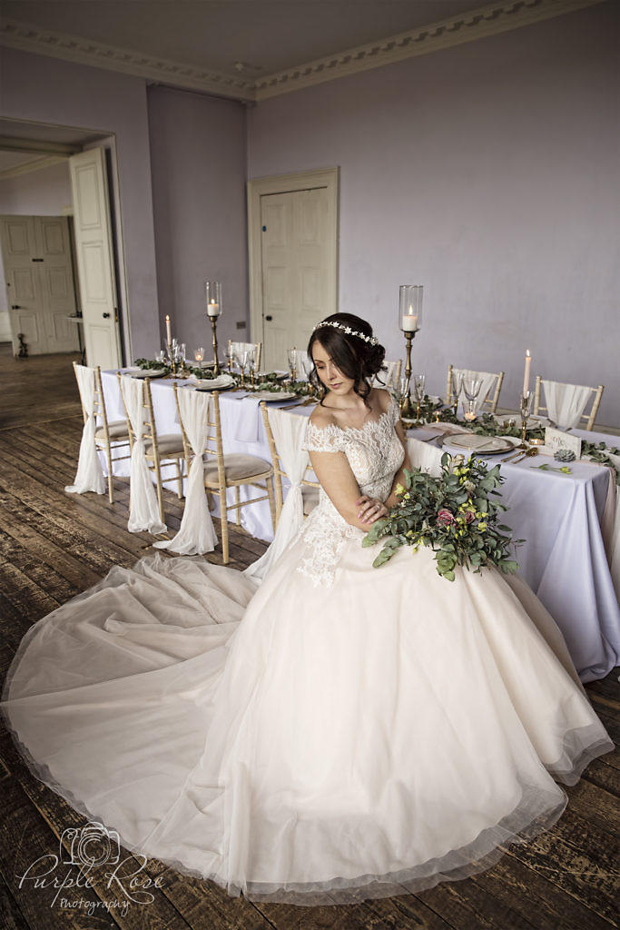 Bride sat on chair with her dress flowing around her