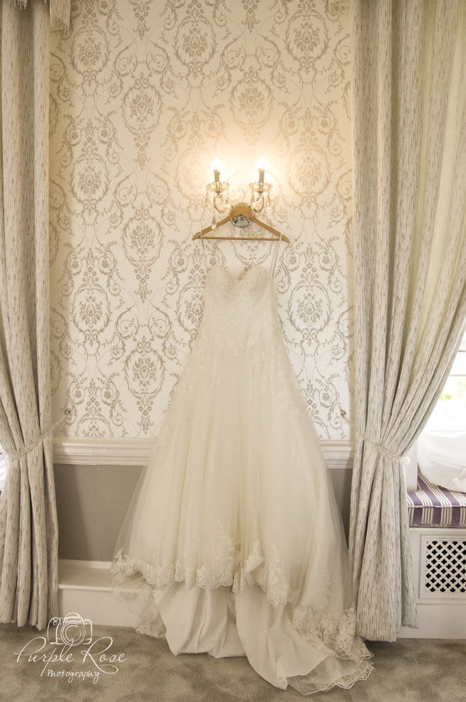 Brides wedding dress hanging on the wall