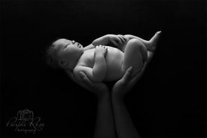 Newborn baby held in mums hands