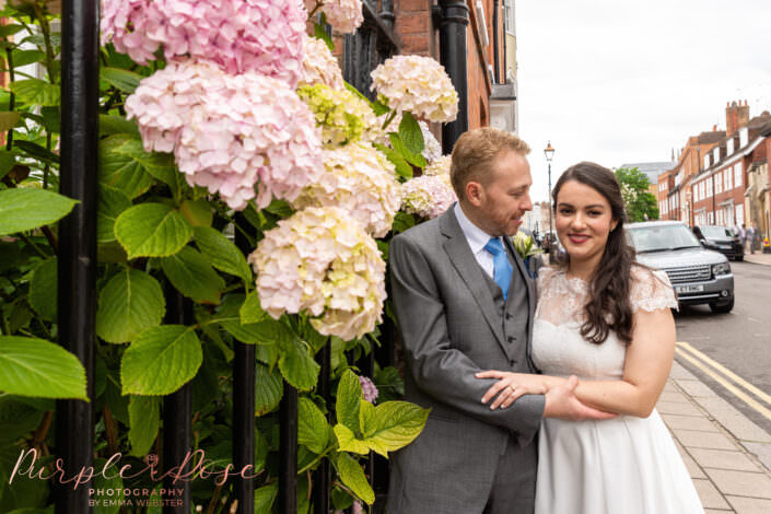 Bride and groom stood by Hydrangea's
