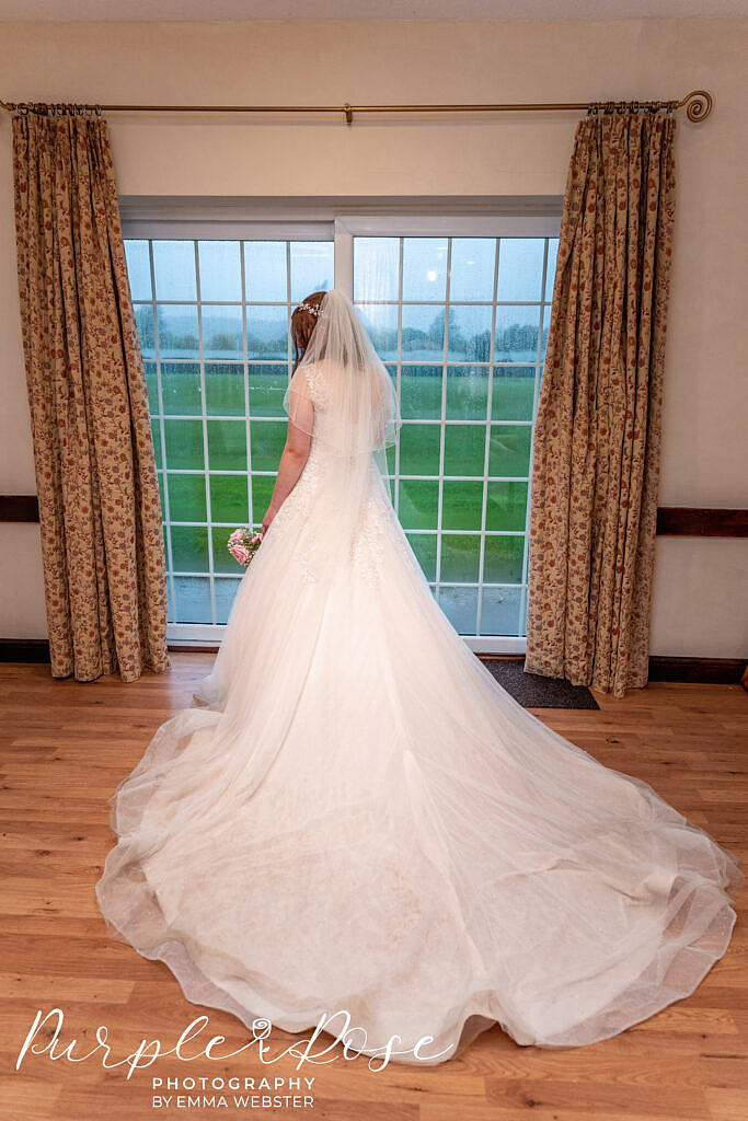 Bride standing at a window