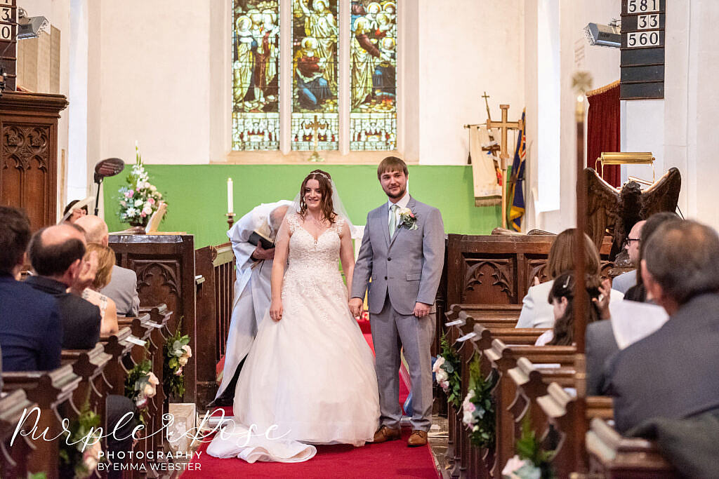 Bride and groom hand in hand at the church