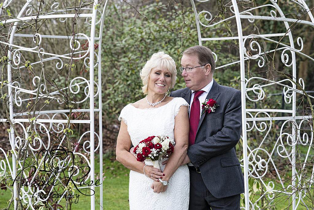 Bride and groom standing together in gardens