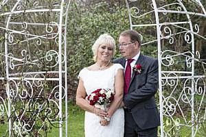 Bride and groom embracing in the gardens