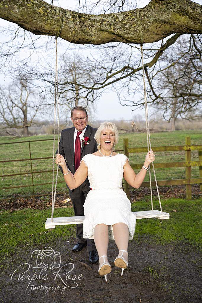 Groom pushing his bride on a swing