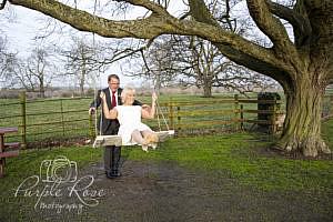 Groom pushing his bride on a swing