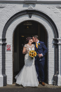 Bride and groom kissing in front of their wedding venue