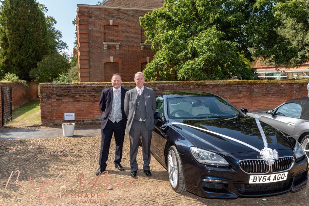 Photograph of groom stood by his wedding car on his wedding day at Chicheley Hall in Milton Keynes