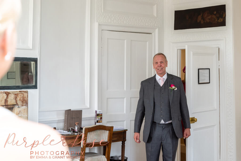 Photograph of father seeing his daughter in her wedding dress for the first time on her wedding dat at Chicheley Hall  in Milton Keynes