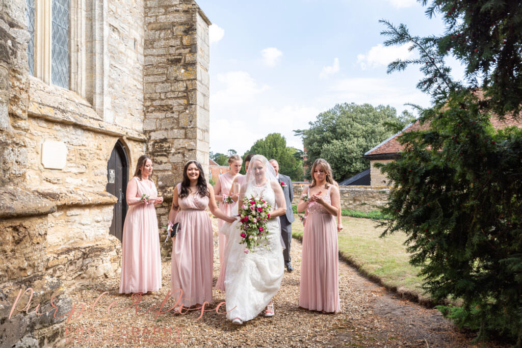 Photograph of a bride and her bridesmaids walking to her wedding ceremony in Milton Keynes