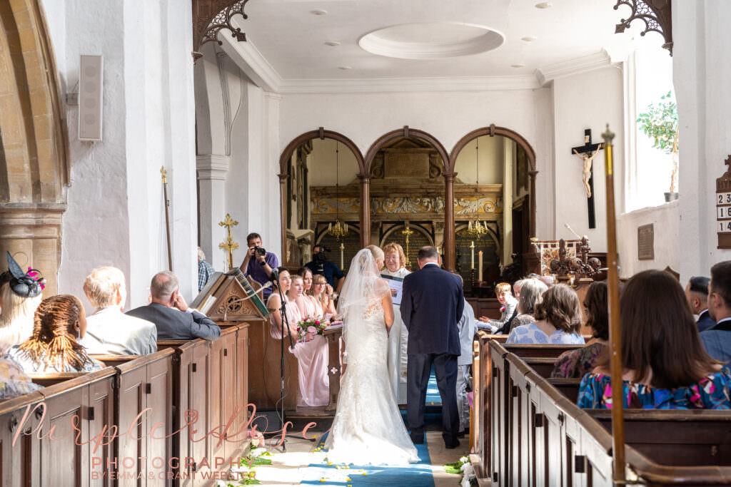 Photograph of bride and groom during their wedding ceremony at Chicheley Church  in Milton Keynes