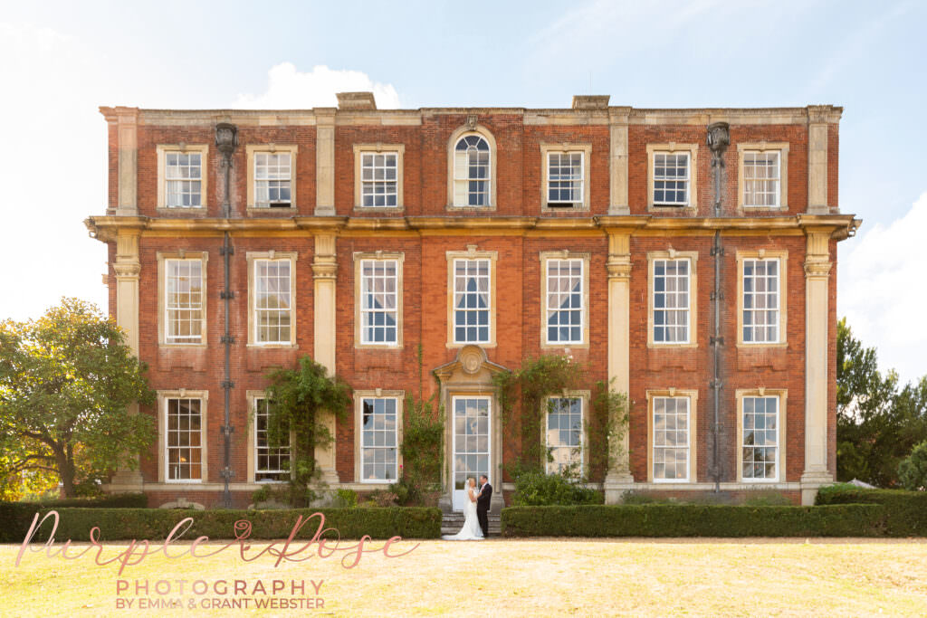 Couple stood outside Chicheley Hall on their wedding day  in Milton Keynes
