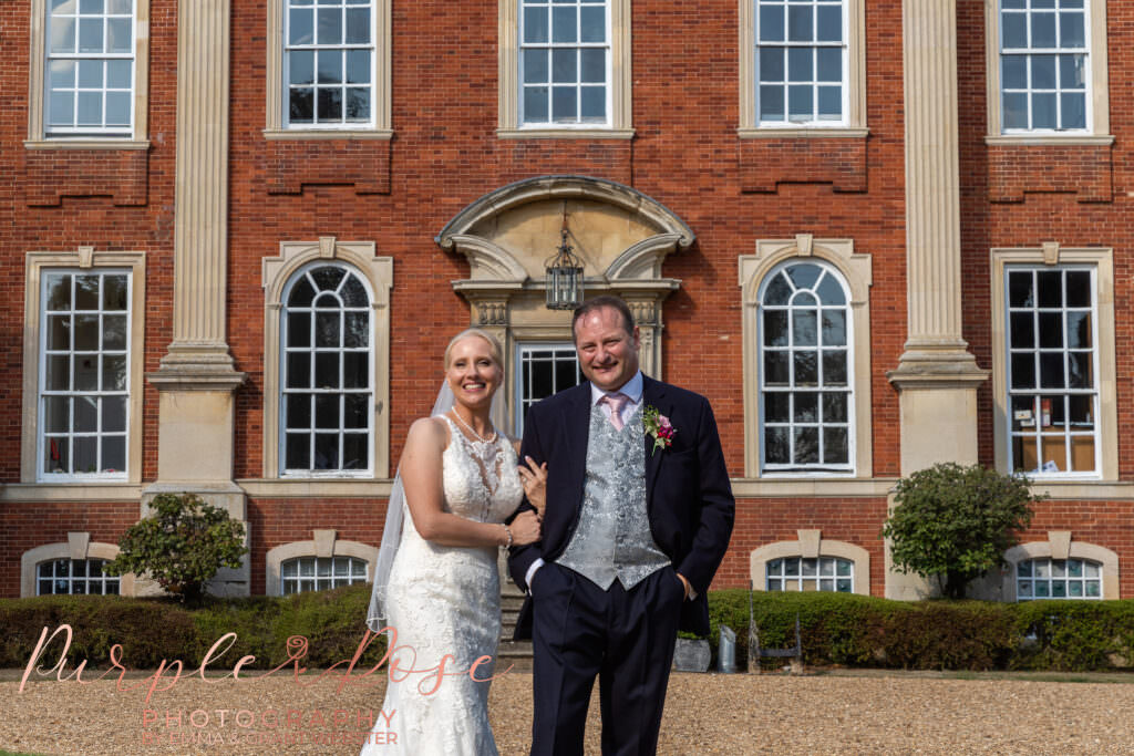 Bride and groom stood in front of Chicheley Hall  in Milton Keynes