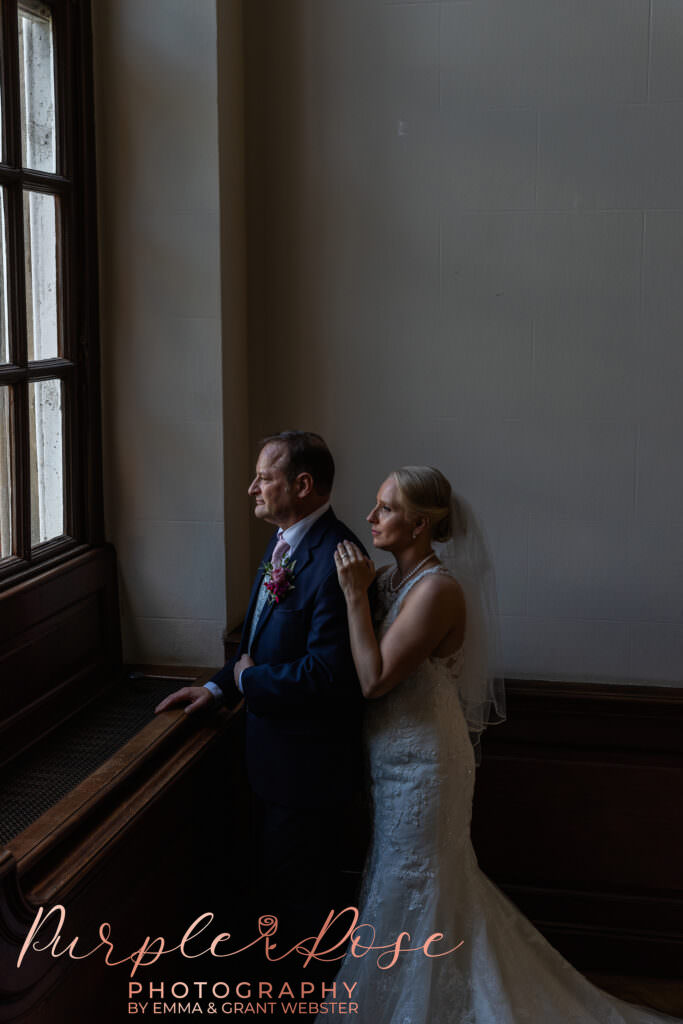 Bride and groom in fornt of a tall window on their wedding day at Chicheley Hall  in Milton Keynes