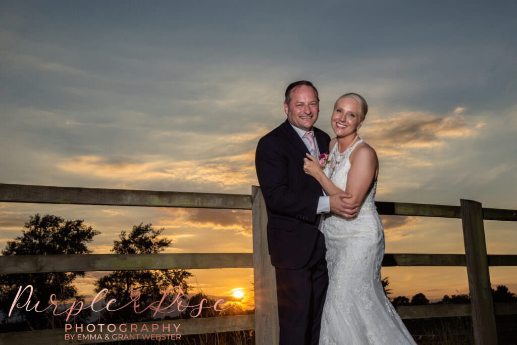 Bride and groom in front of a sunset at a photo shoot on their wedding day in Milton Keynes