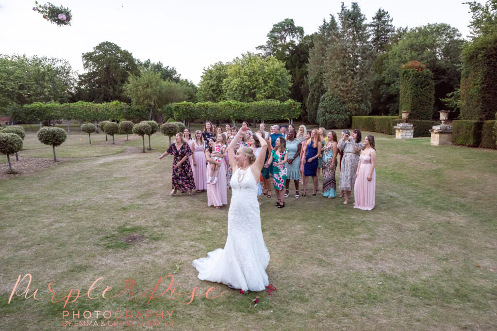 Bride throwing her wedding bouquet to her freinds  in Milton Keynes