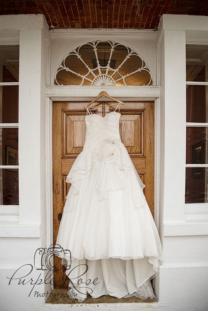 Wedding dress hanging in a doorway