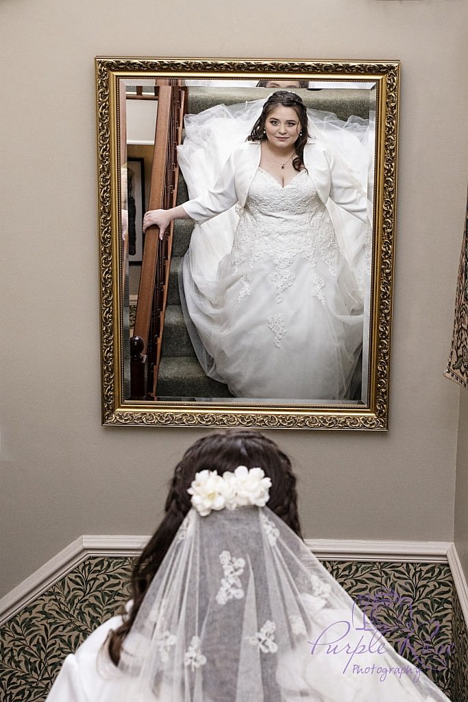 Bride viewing her reflection as she walks down some stairs