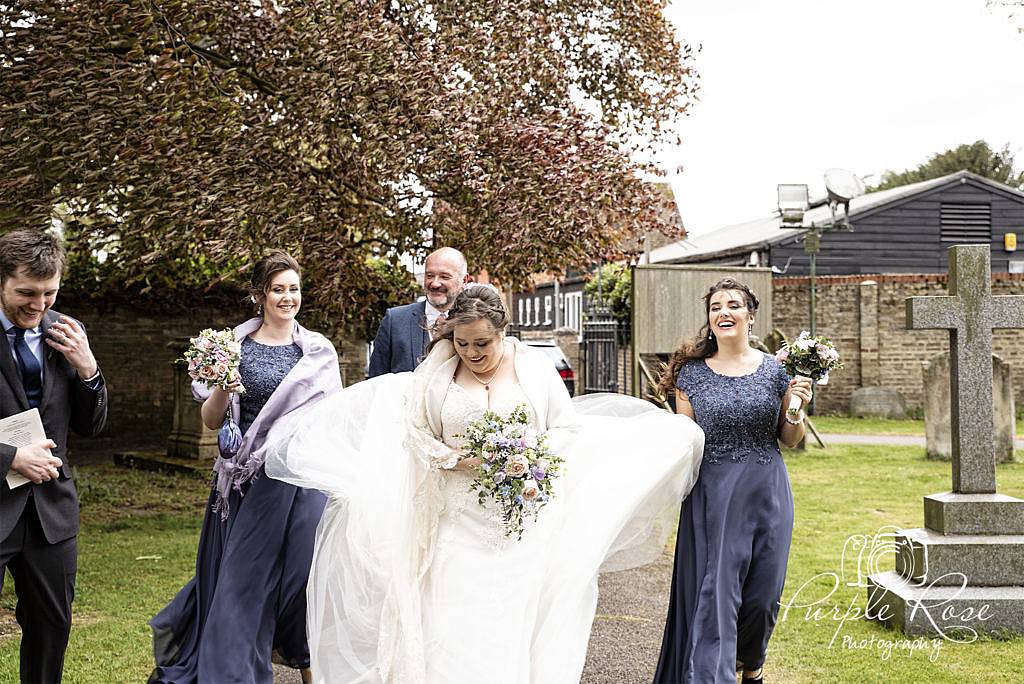 Bridal party walking to the church on a windy morning