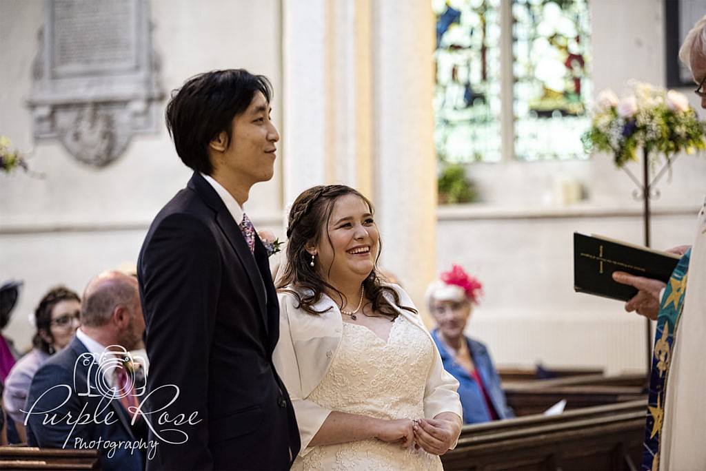 Bride and groom smiling during their wedding ceremony