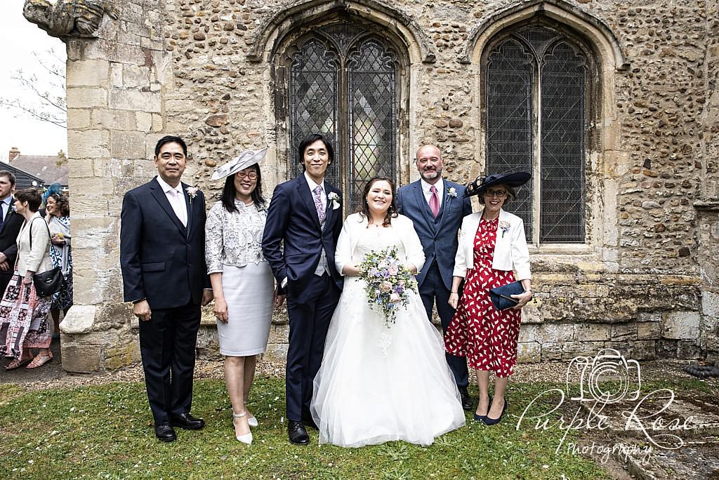 Bride, groom and family posing for a photo