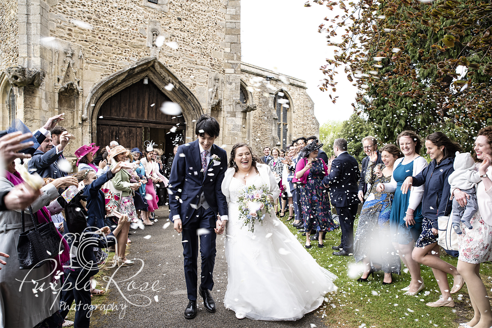 Bride and groom being showered in confetti as they leave the church