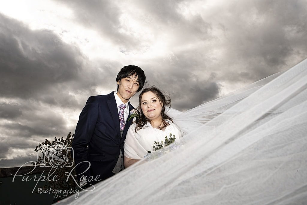 Bride and groom in front of a dramatic sky