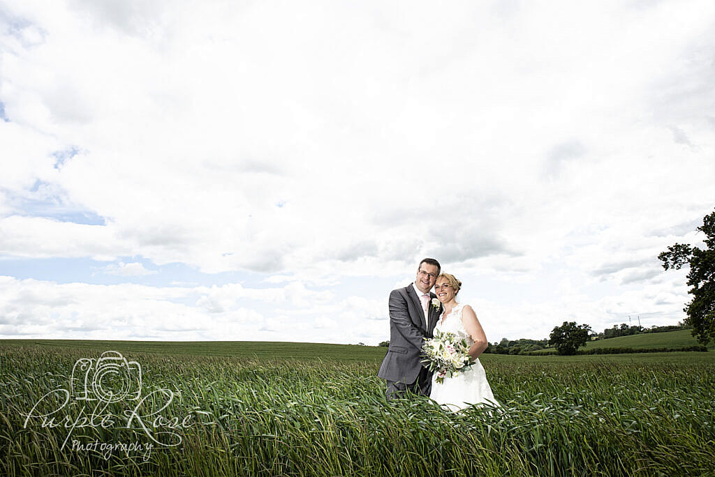 Bride and groom standing in a field