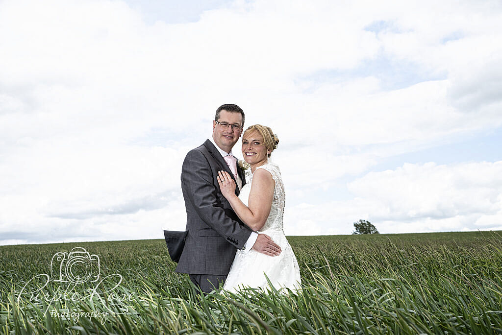 Bride and groom embracing on a windy day