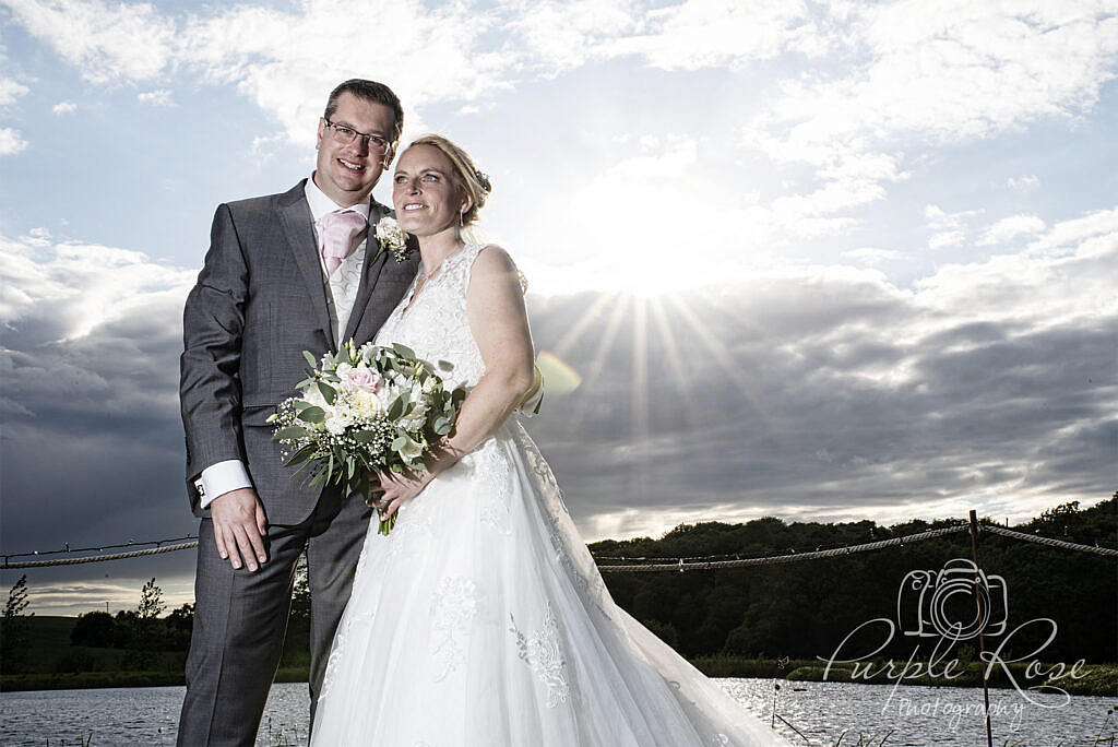 Photo of bride and groom with sun causing a star burst