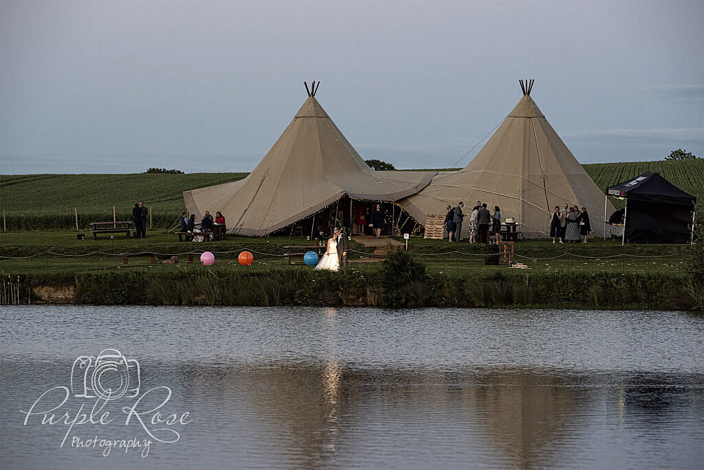 Bride and groom standing in front of tipi's