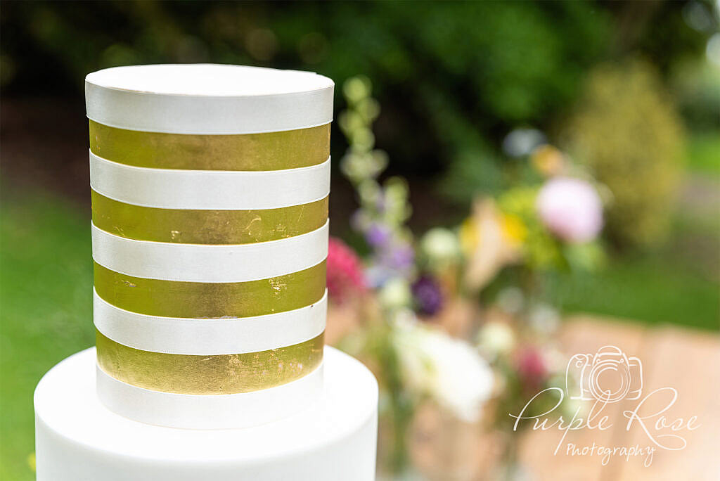 Gold and white striped top of wedding cake