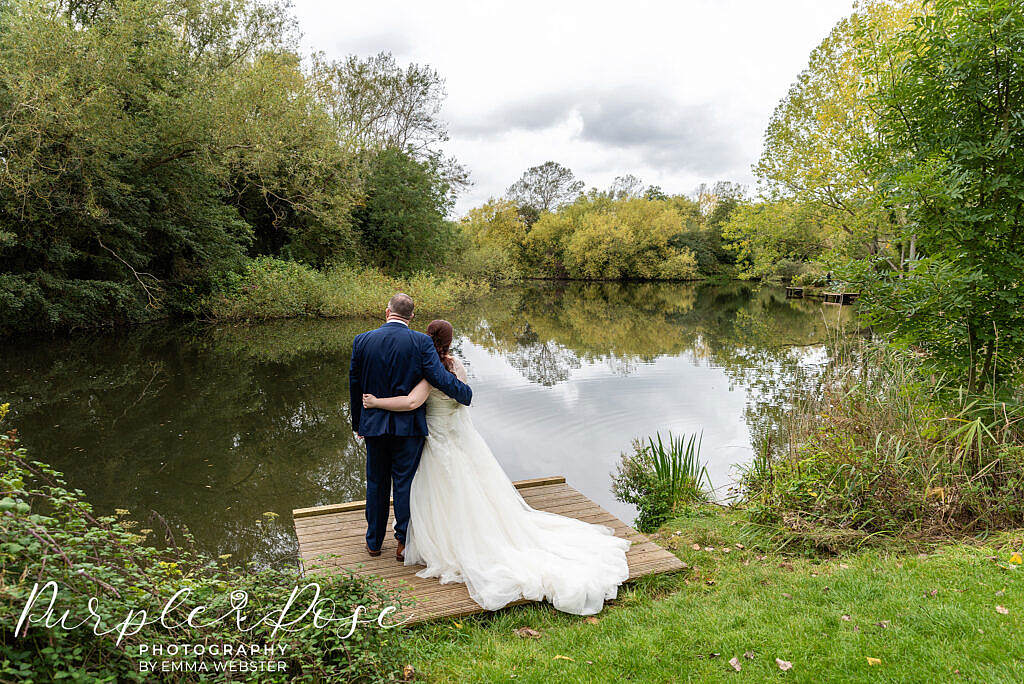 Bride and groom looking out onto a lake