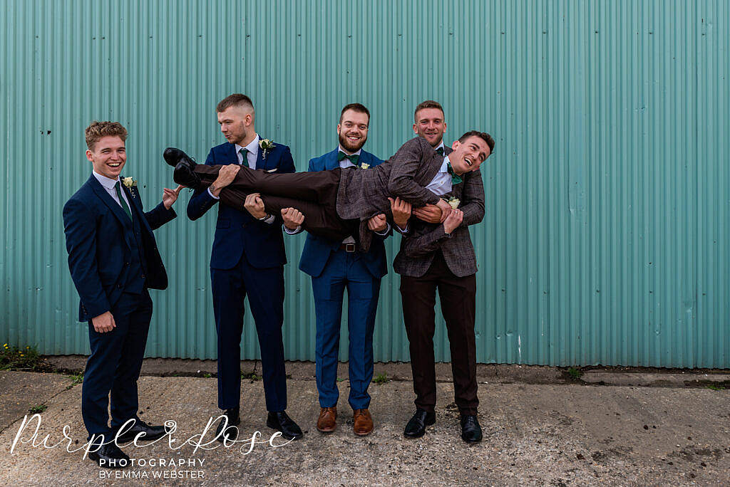 Groomsmen carry the groom