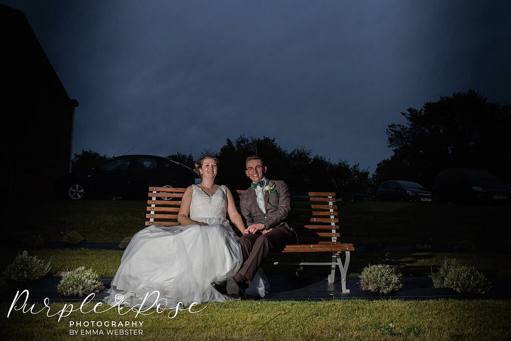 Bride and groom sat on a bench