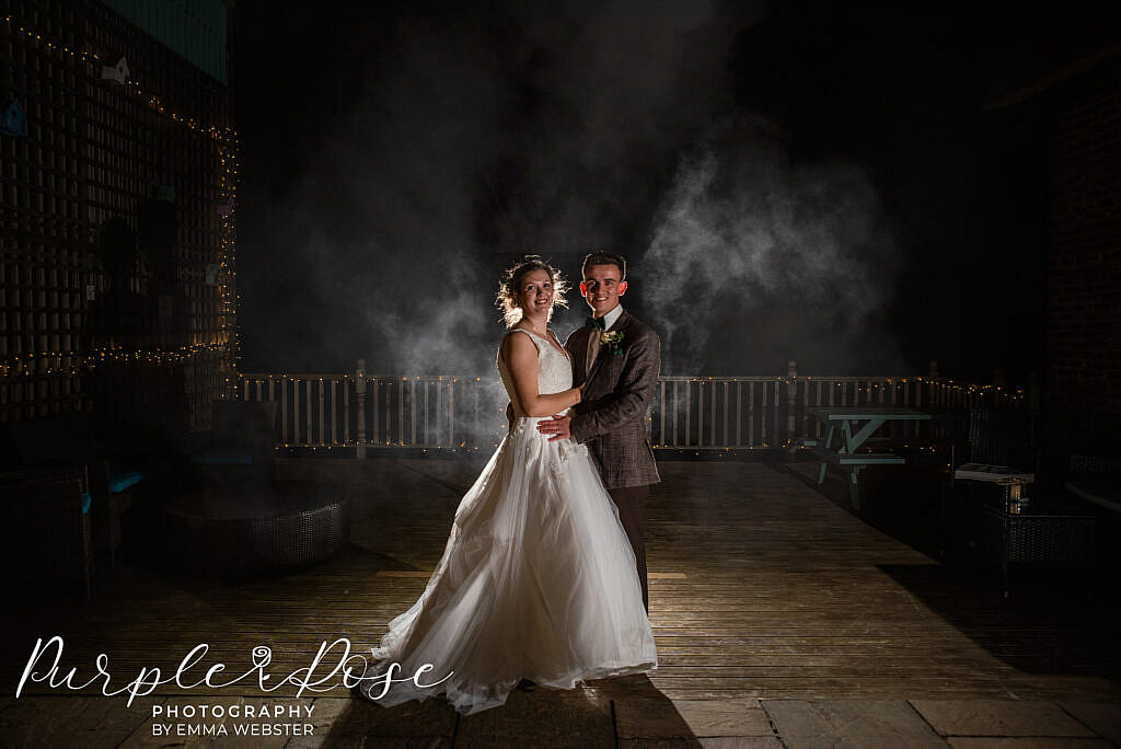 bride and groom with a dark smokey back ground
