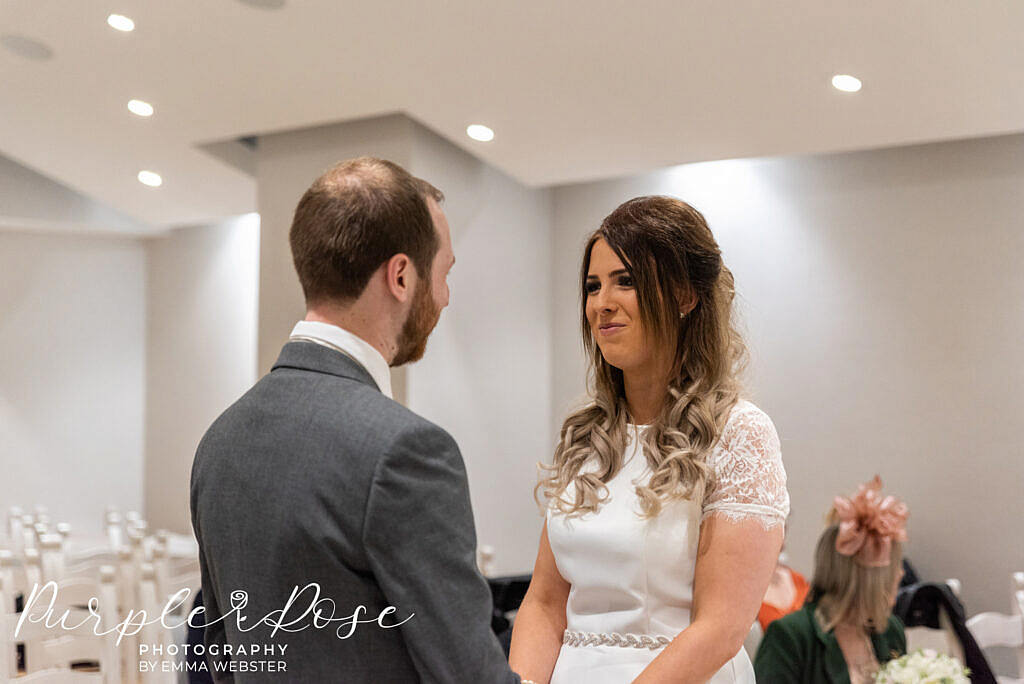 Bride smiling at her groom during the ceremony