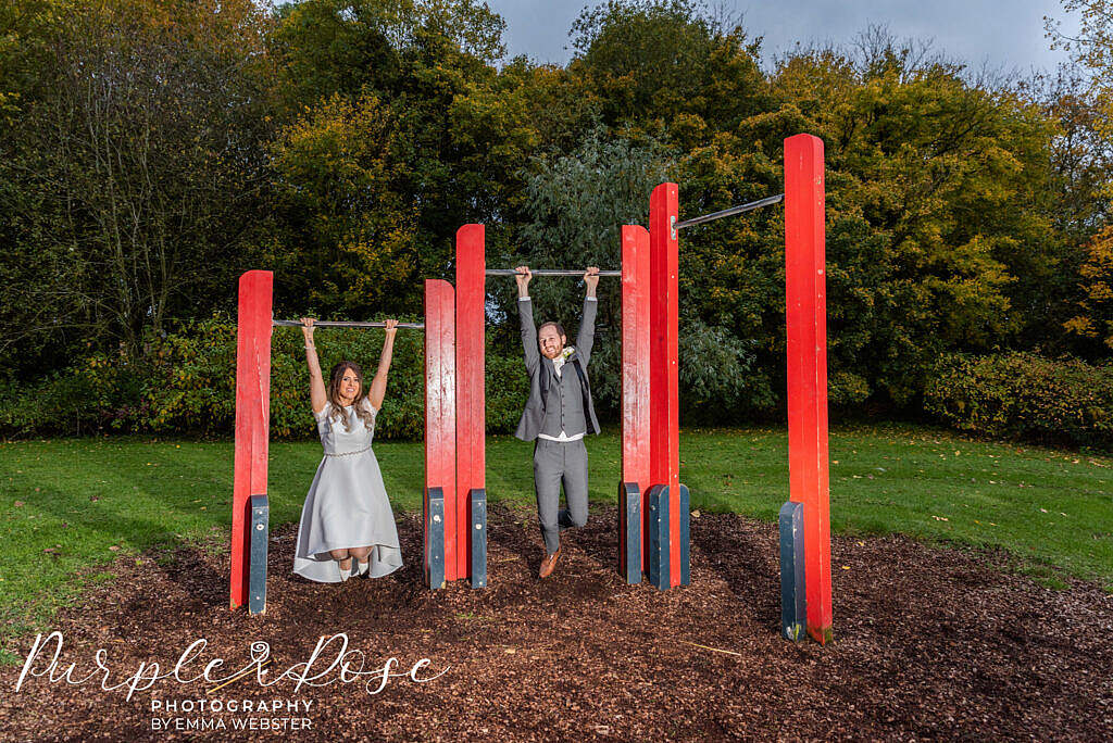 Bride and groom playing on a climbing frame