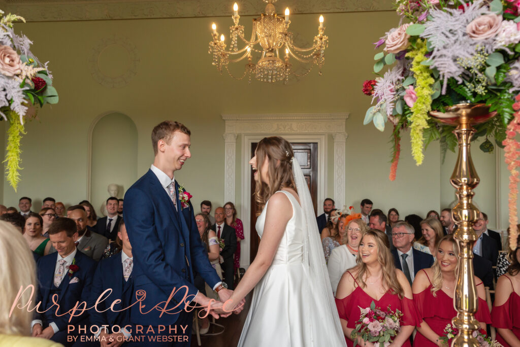 Photo of bride and groom smiling during their wedding ceremony in Milton Keynes