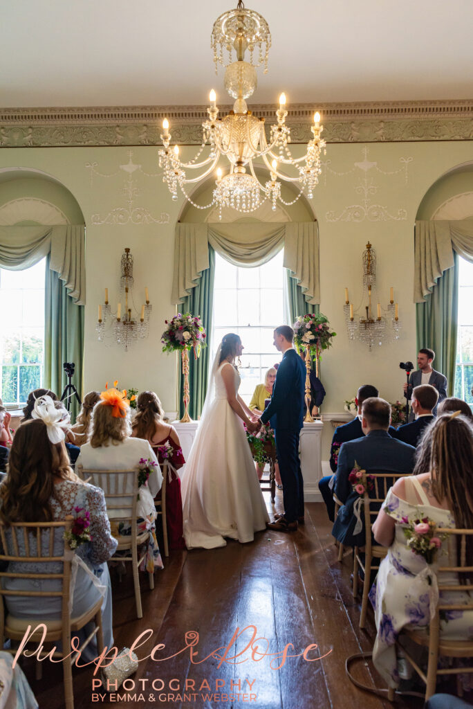 Photo of bride and groom stood hand in hand during their wedding ceremony in Milton Keynes