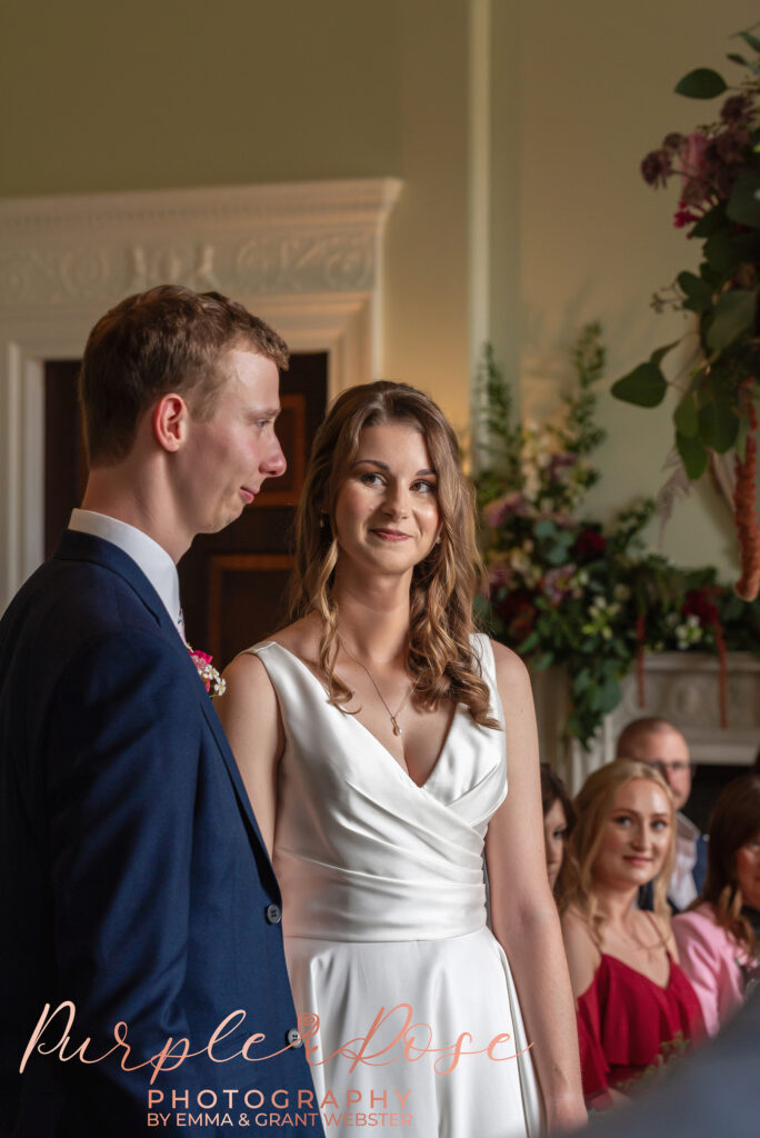 Photo of bride smiling at her husband during their wedding ceremony in Milton Keynes