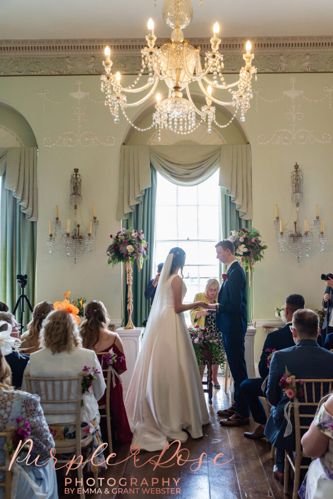 Photo of bride and groom exchanging wedding rings during their ceremony in Milton Keynes