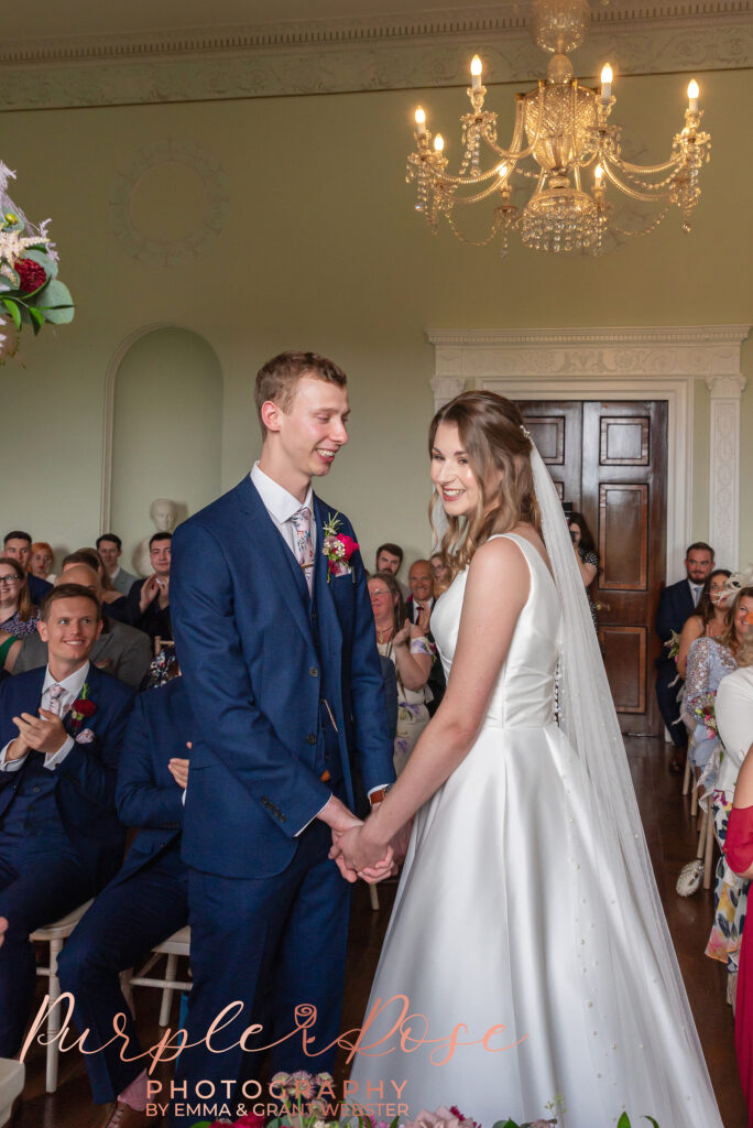 Photo of bride and groom smiling during their wedding ceremony in Milton Keynes